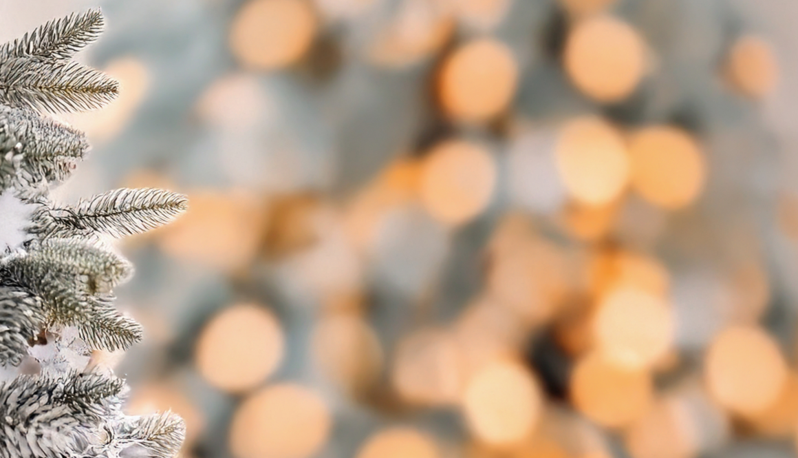 Verschwommene weihnachtliche Lichter, an der linken Seite eine schneebedeckte Tanne